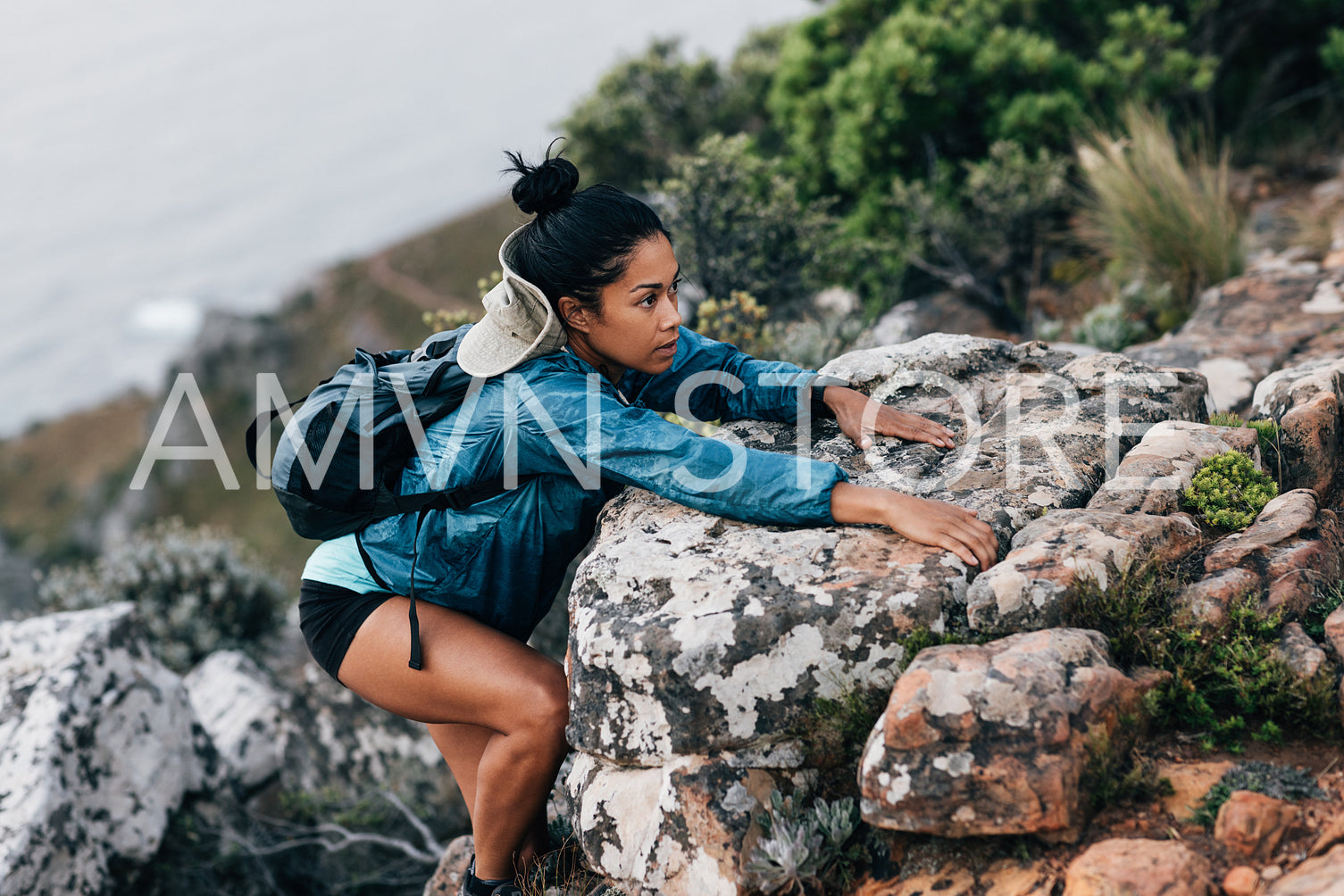 Young woman climbing on a mountain. Sporty woman on a hike.