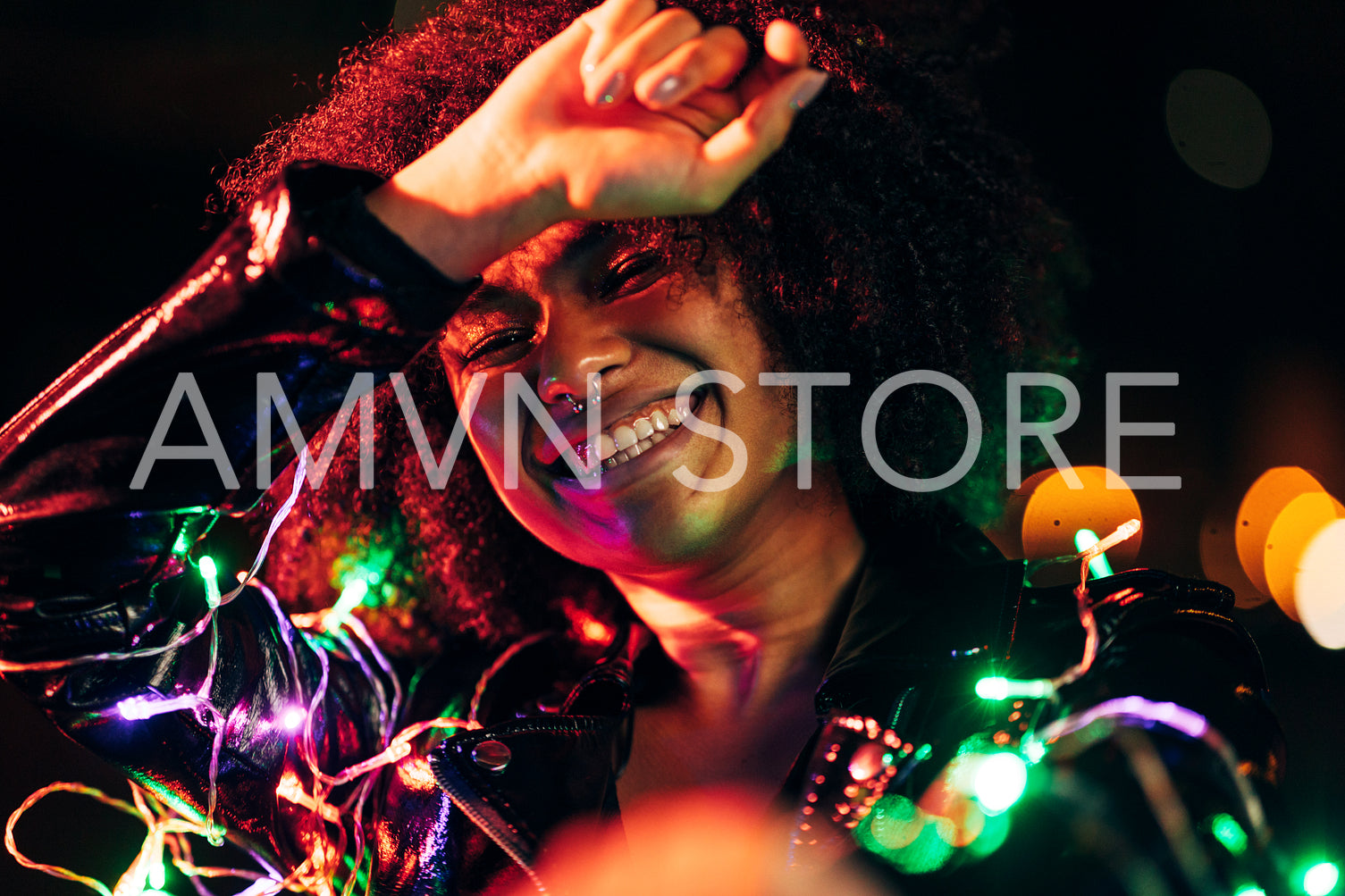 Happy woman posing at night with colored and christmas lights	