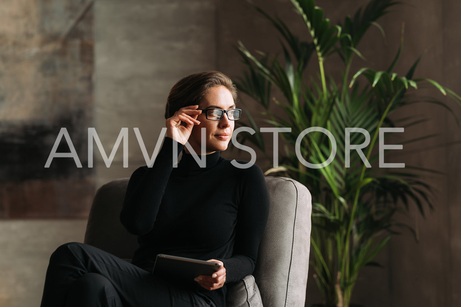 Middle aged businesswoman adjusting her eyeglasses and looking away