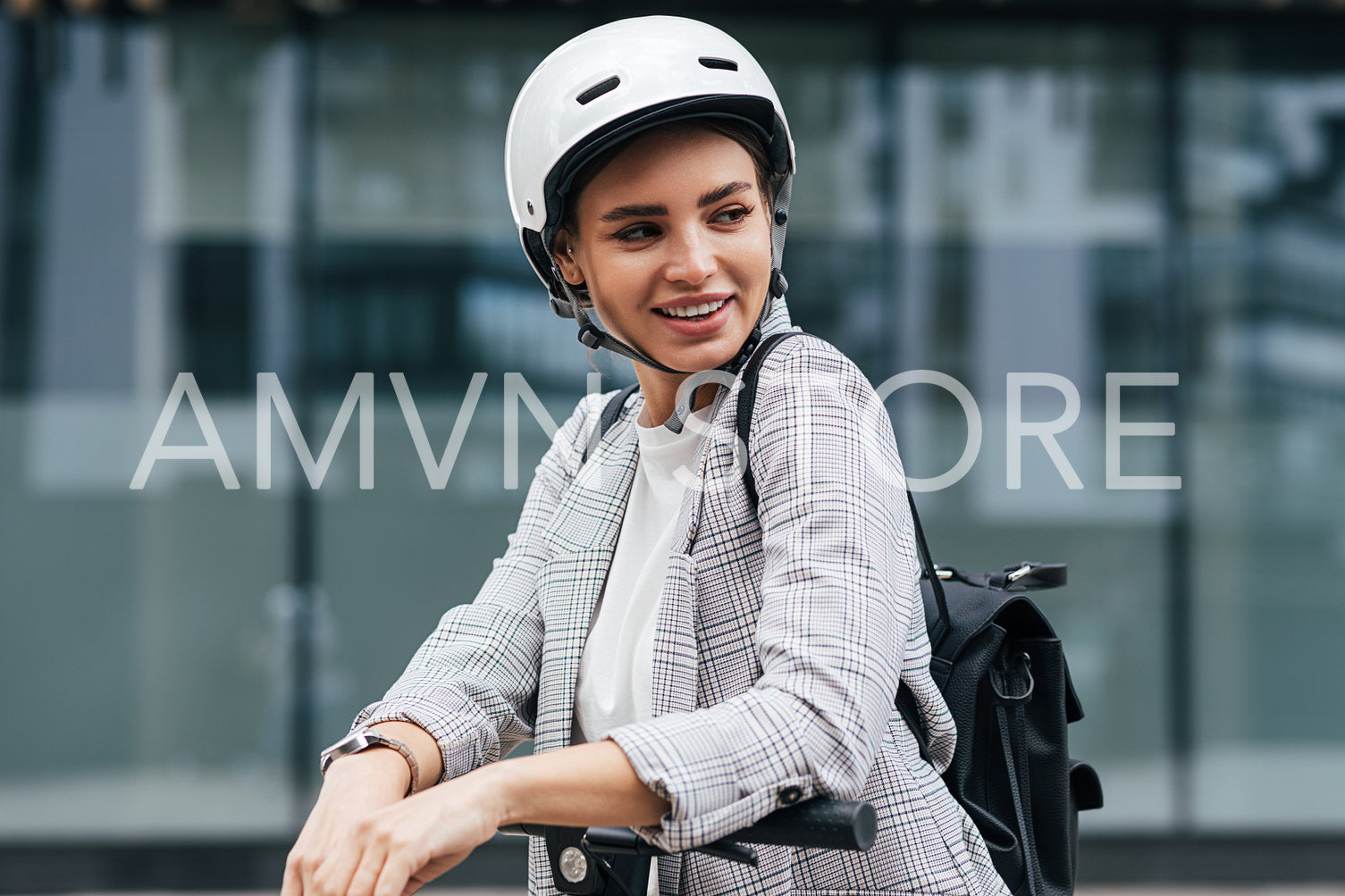 Young businesswoman with electric scooter looking away. Cheerful female in safety helmet wearing backpack standing outdoors.