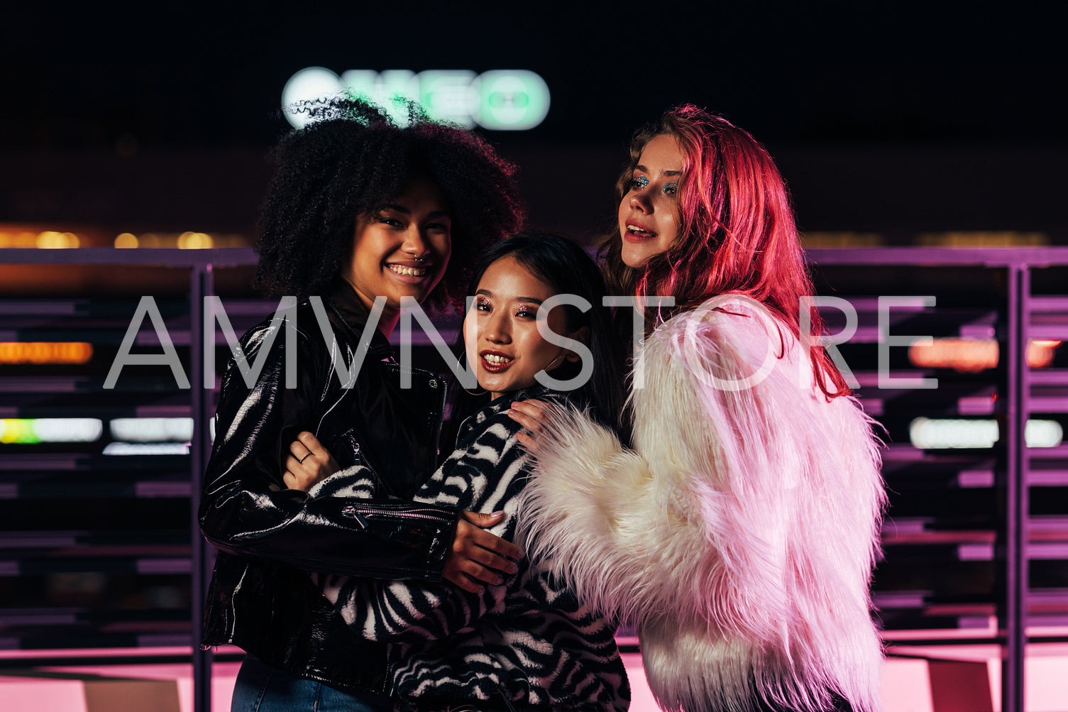 Smiling girls standing together outdoors at night and having fun	