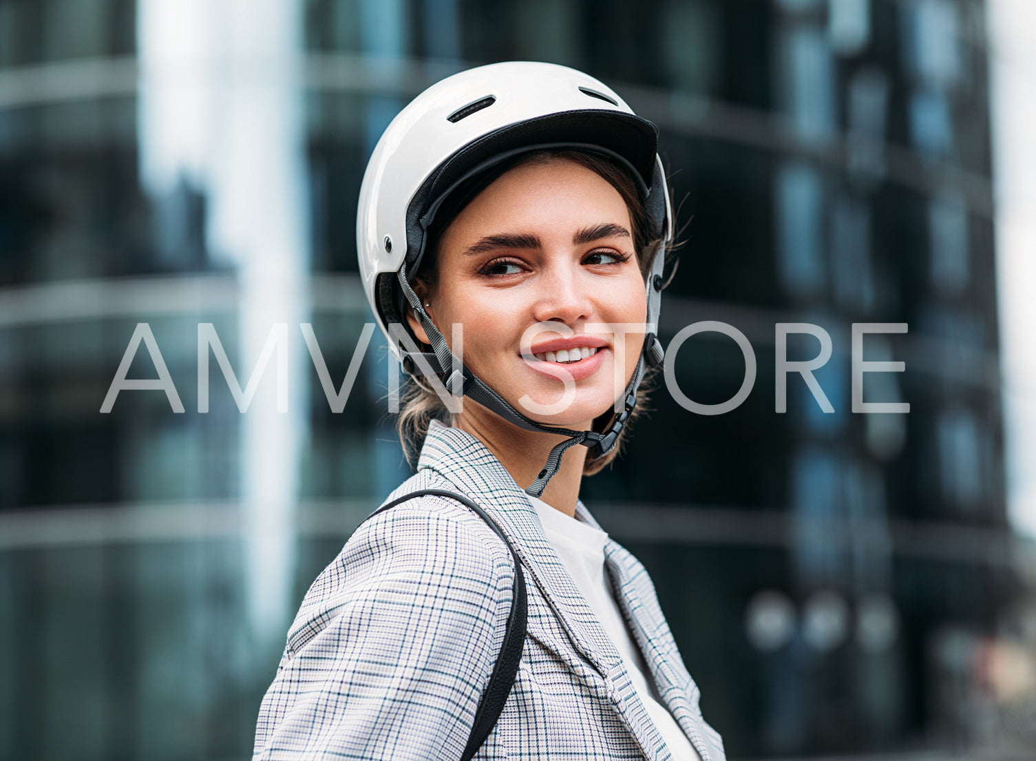 Portrait of a smiling woman wearing cycling helmet standing in front of an office building