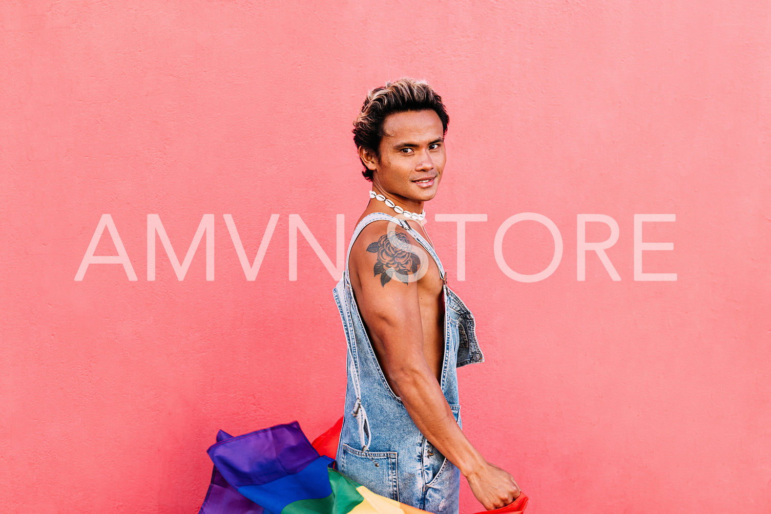 Handsome guy posing outdoors with LGBT flag and looking at camera