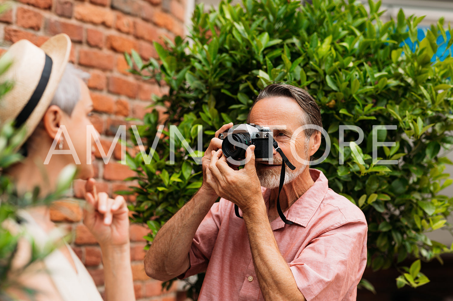 Senior male doing photographs of her wife in the park