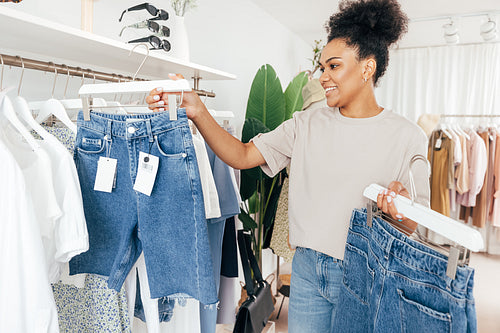 Saleswoman arranging clothes in a rack in her small boutique