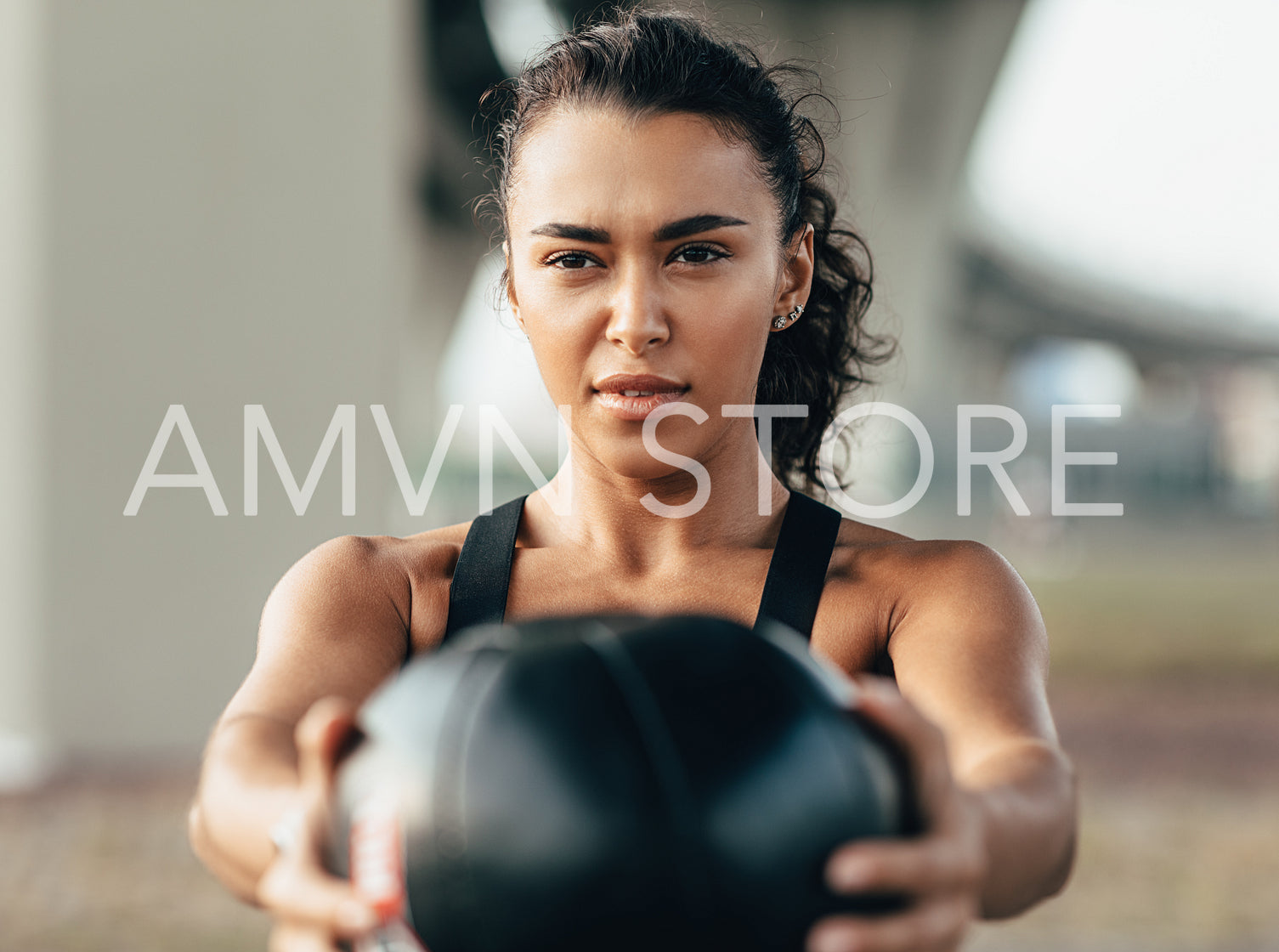 Muscular sportswoman doing exercise with a medicine ball outdoors	