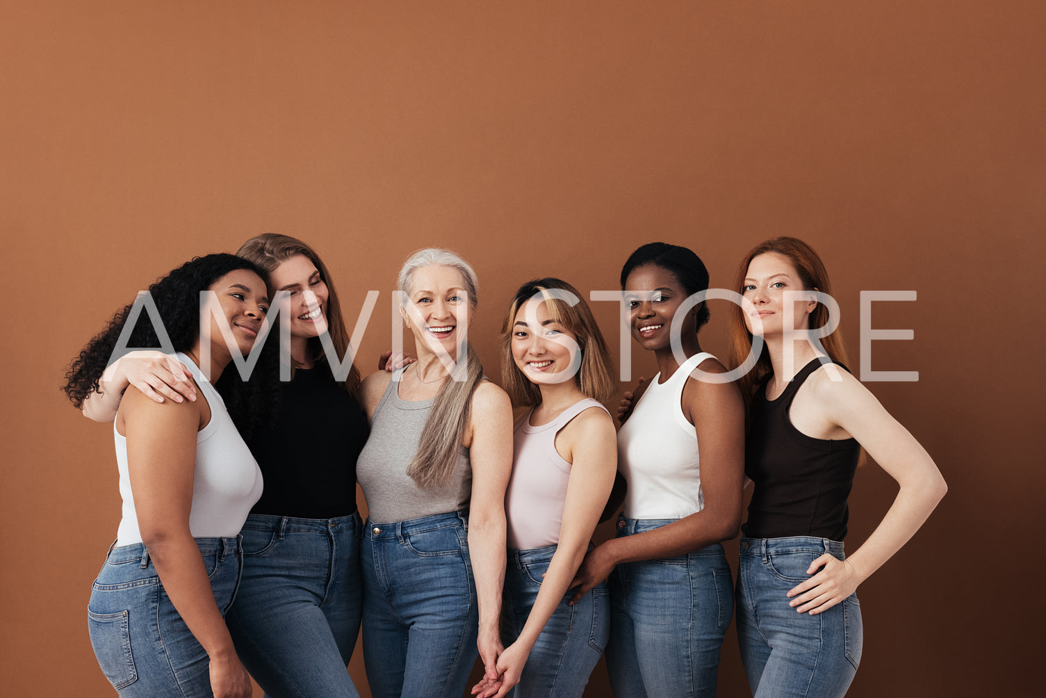 Multi-ethnic group of women of different ages posing against brown background looking at camera