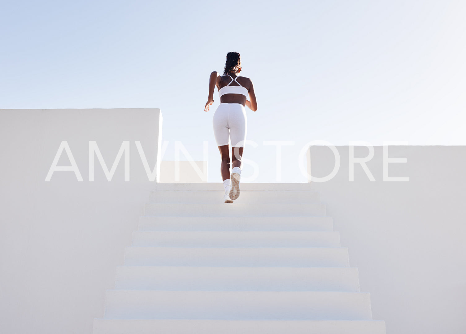 Rear view of a full length of a slim female athlete running up on stairs. Back view of a woman sprinting on stairs.