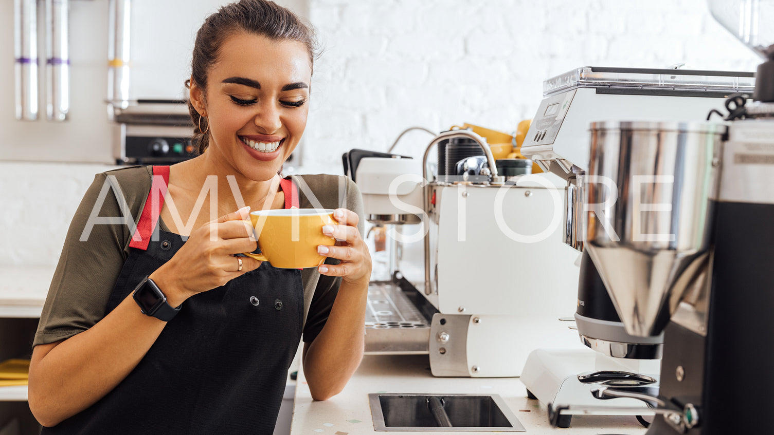 Laughing barista holding a mug. Smiling waitress taking a break in the cafeteria.