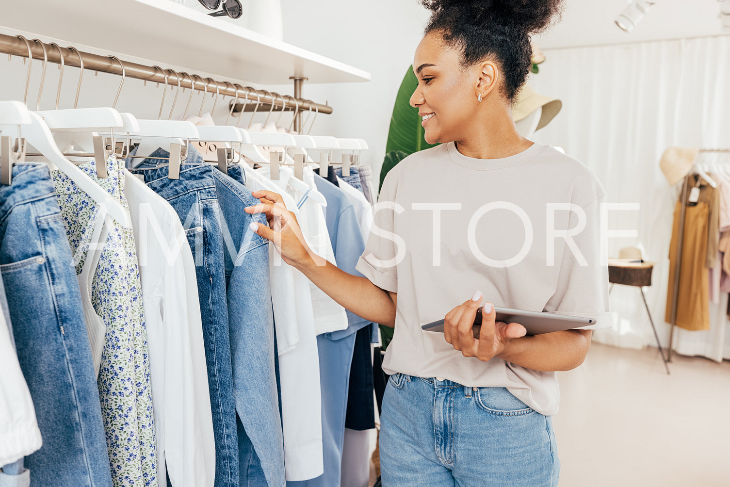 Small clothes store owner holding a digital tablet makes an inventory