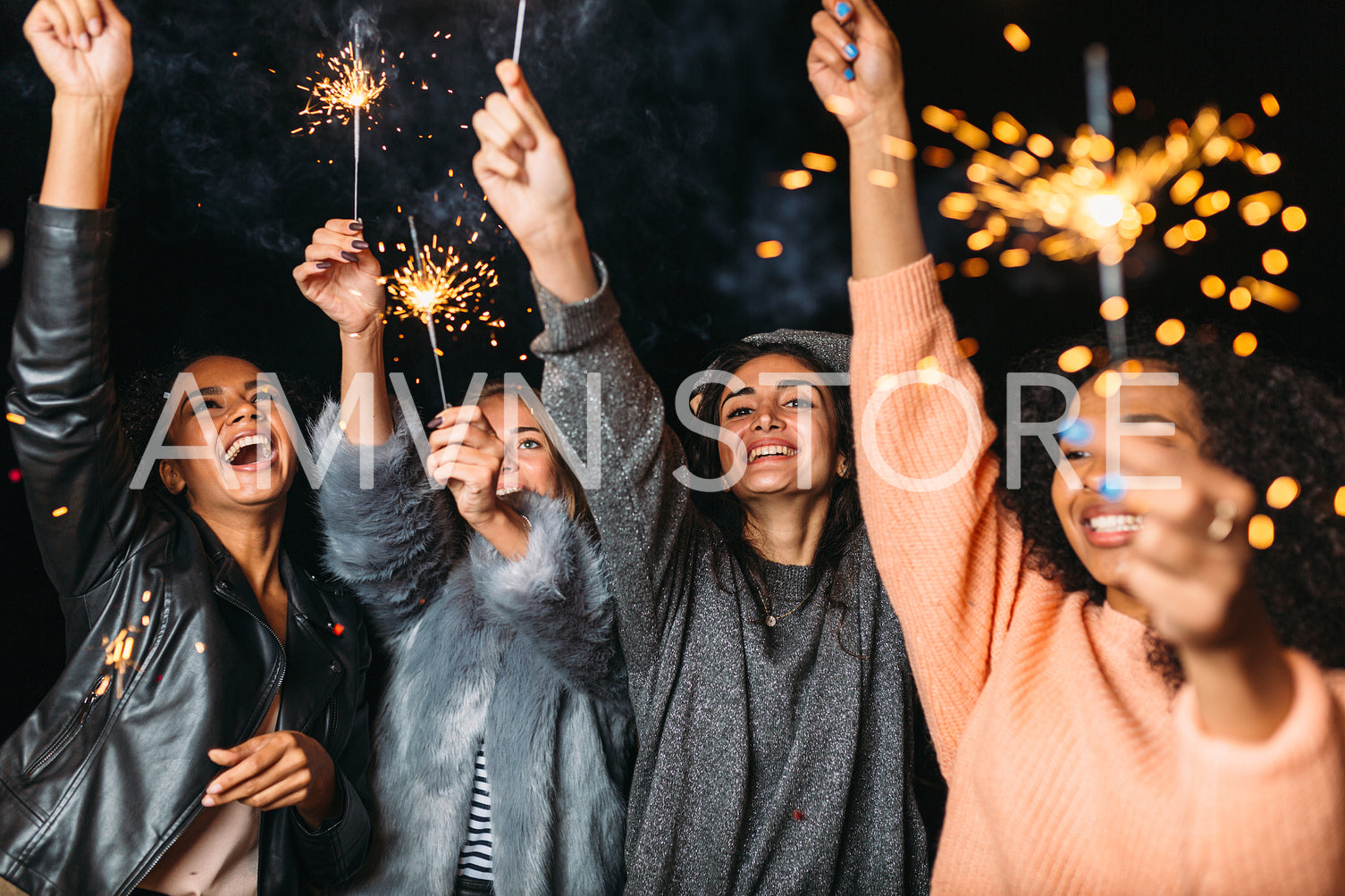 Group of young female friends having fun, raised hands up with sparklers	