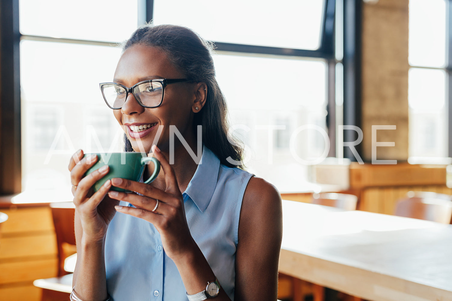 Portrait of young woman wearing glasses holding a cup of coffee	