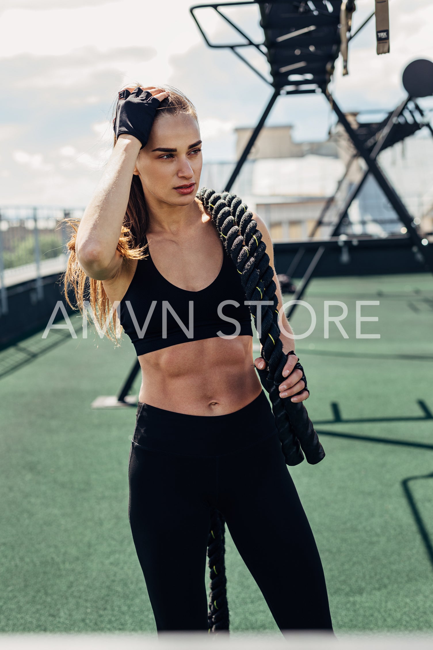 Muscular woman holding a battle ropes after intense training	
