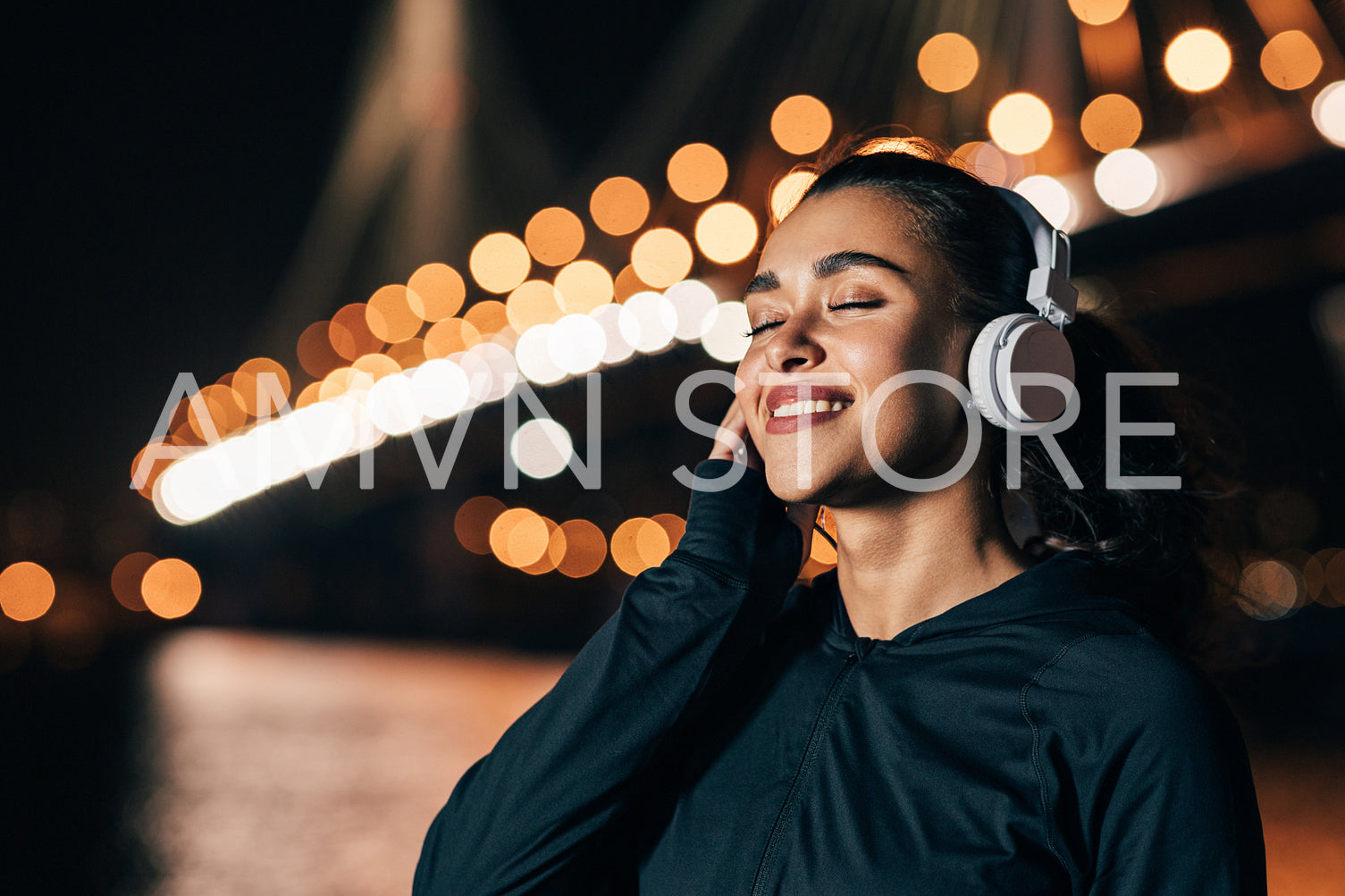 Portrait of a young woman enjoying music at night outdoors