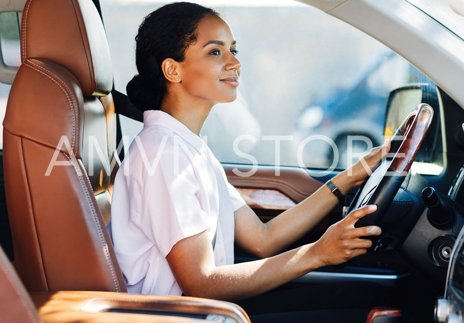 Confident young woman driving car. Side view of female holding a steering wheel.	