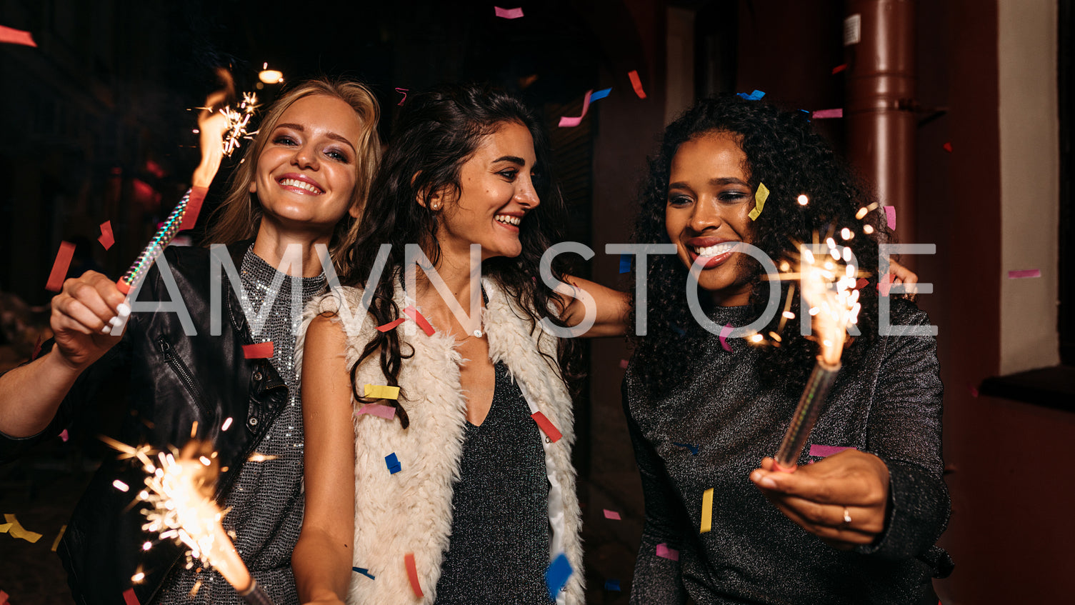 Three happy women walking and hugging on night street	