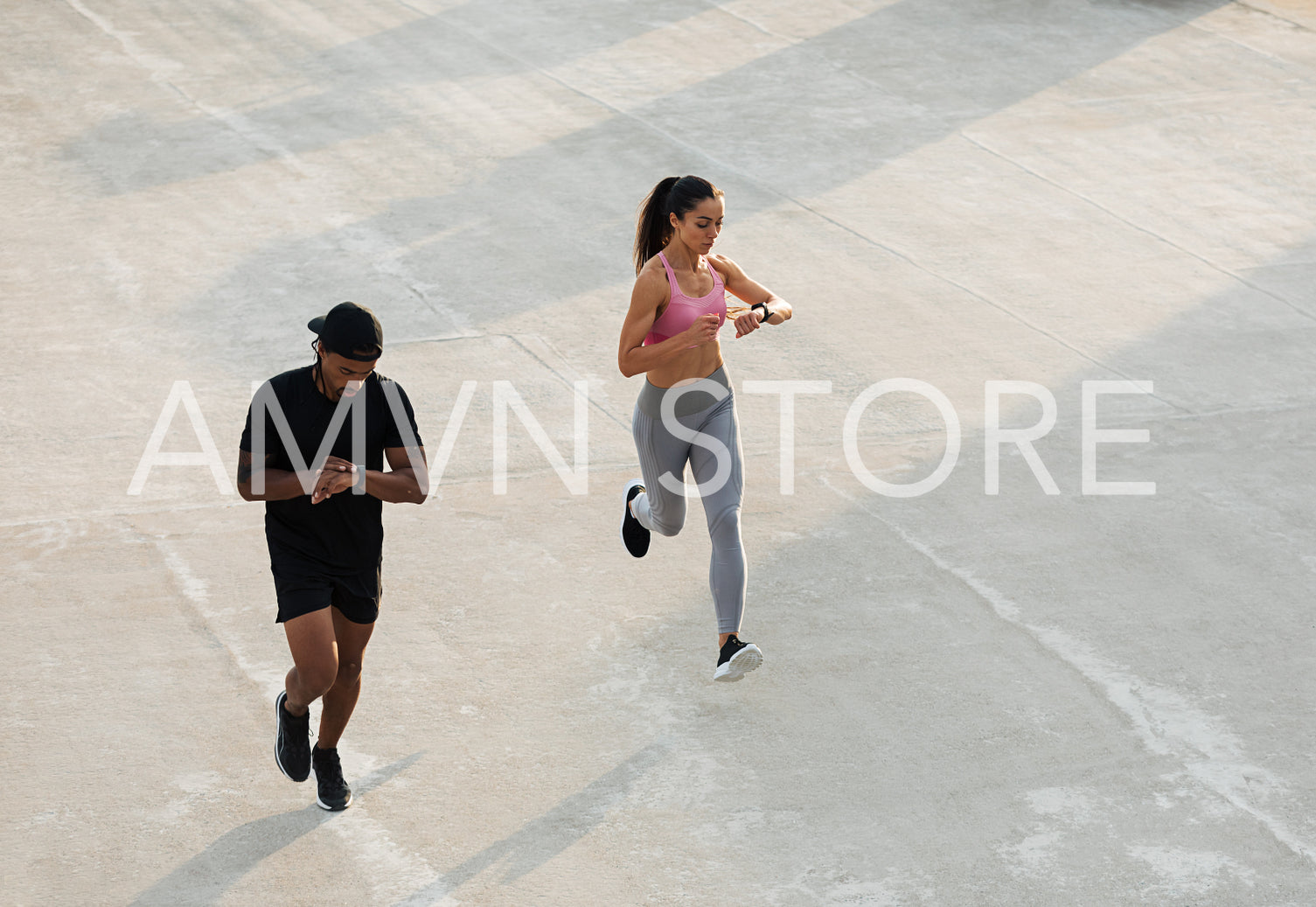 Two athletes checking their smartwatches during a run on the roof