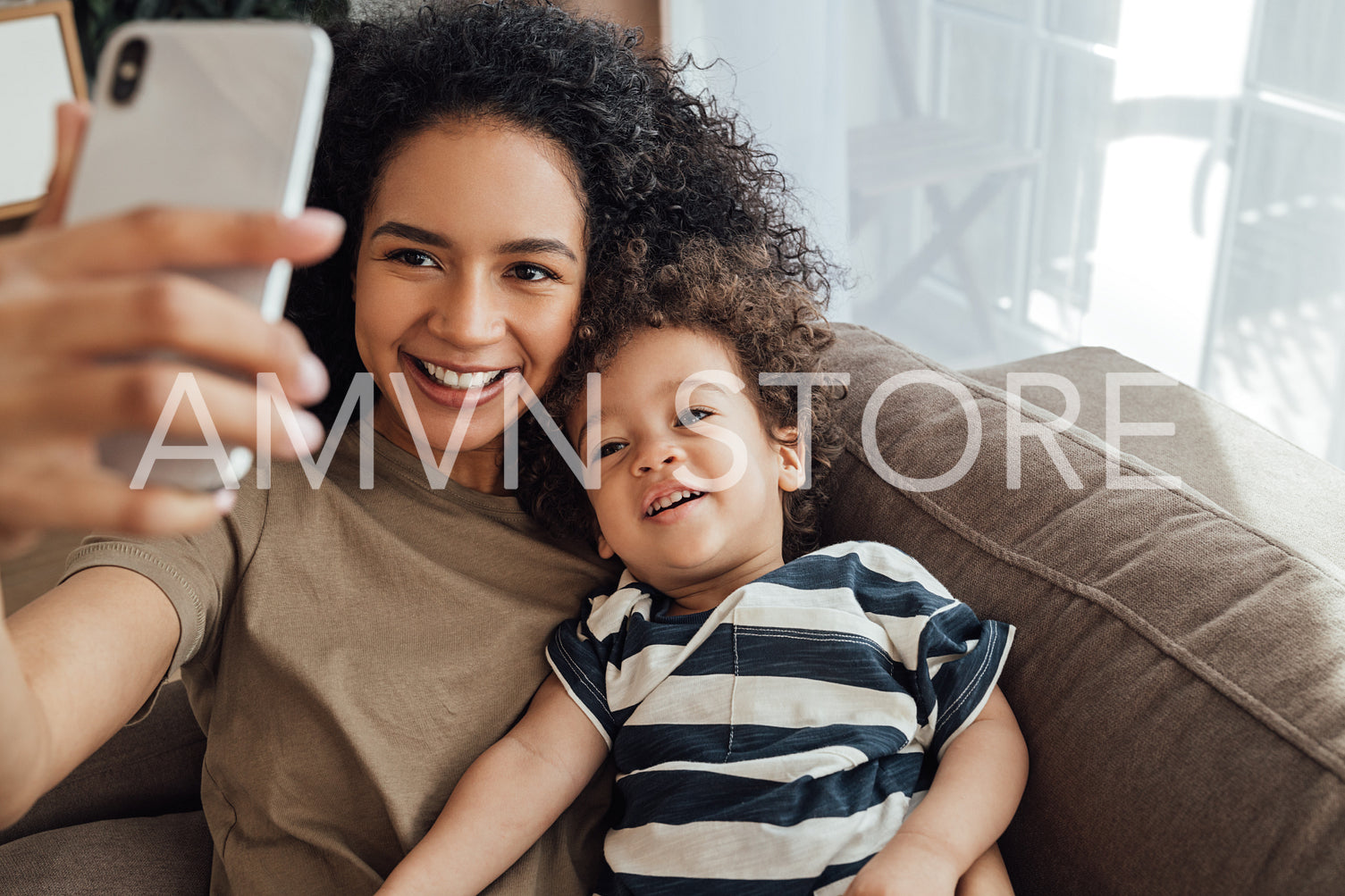 Young mother and her little son spending time together. Happy boy taking a selfie with his mother.	