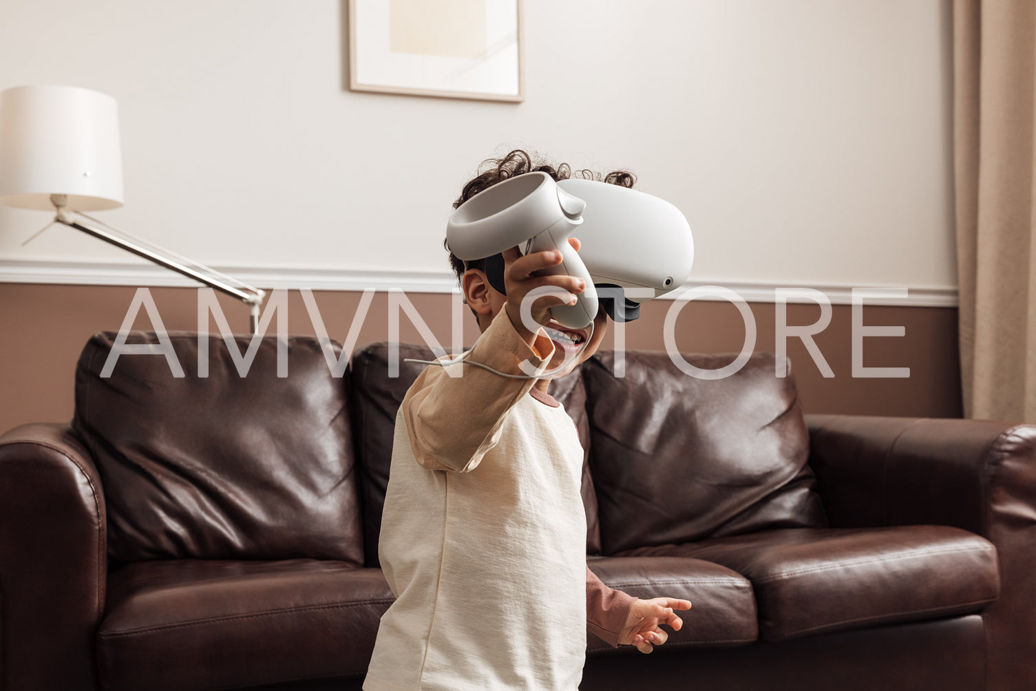 Little smiling boy wearing VR goggles using a controller for int