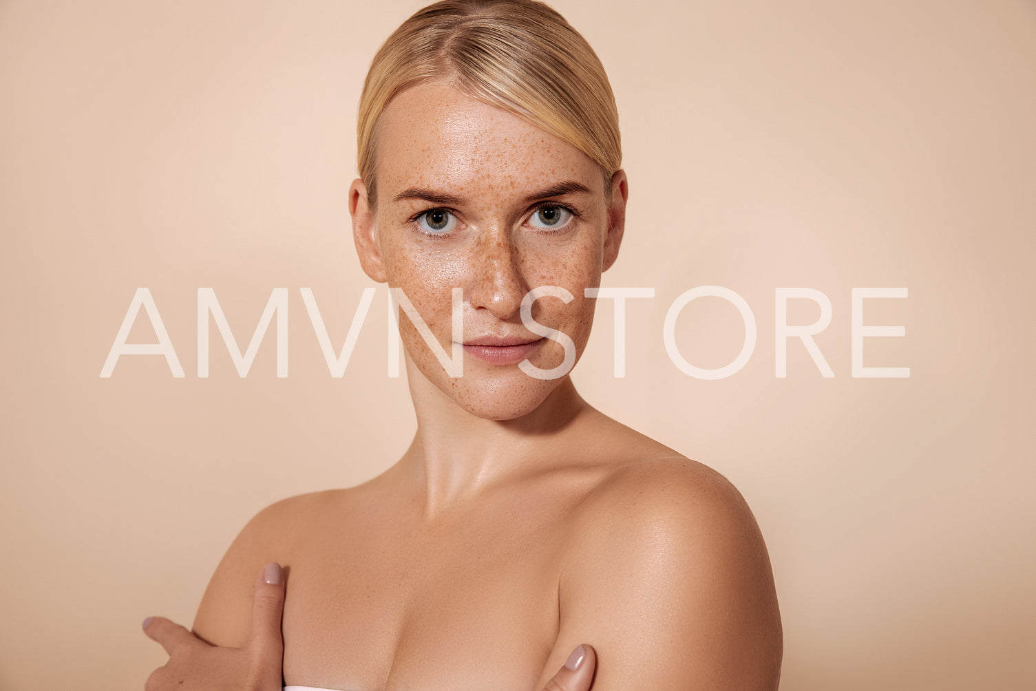 Young woman with perfect skin with freckles posing in studio and