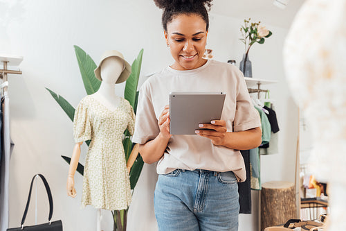 Local clothing store owner standing with digital tablet