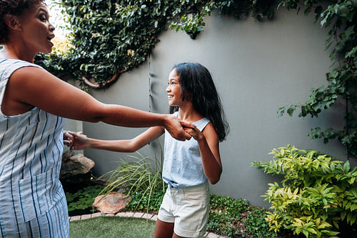 Mature woman with her granddaughter holding hands enjoying time together outdoors