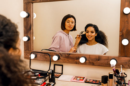 Two people in dressing room looking at mirror