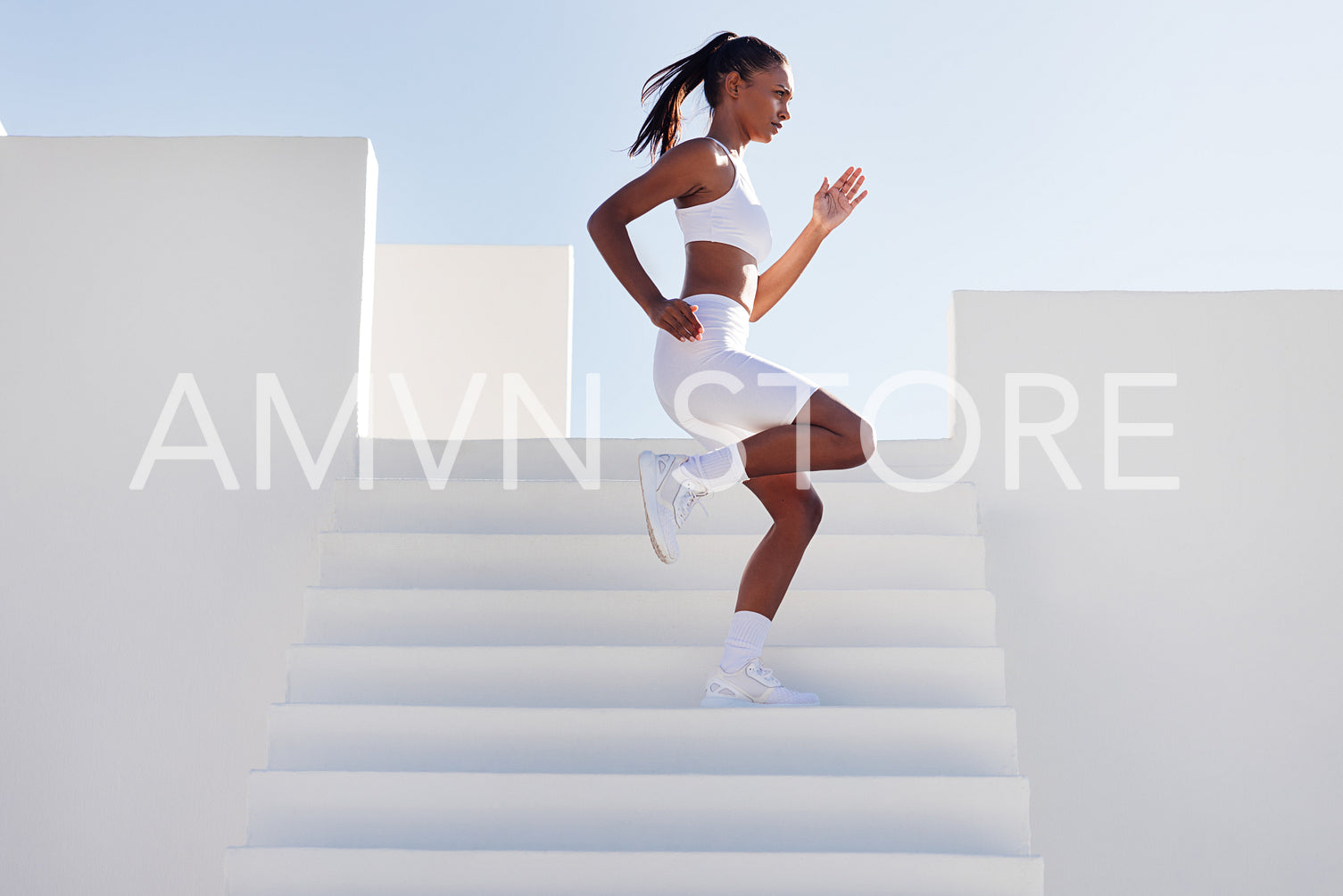 Young slim woman running down stairs while exercising outdoors. Side view of fit female running down on stairs.