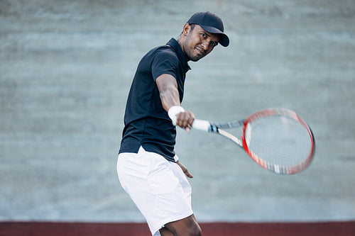 Young tennis player practicing backhand volley hit on court outdoors