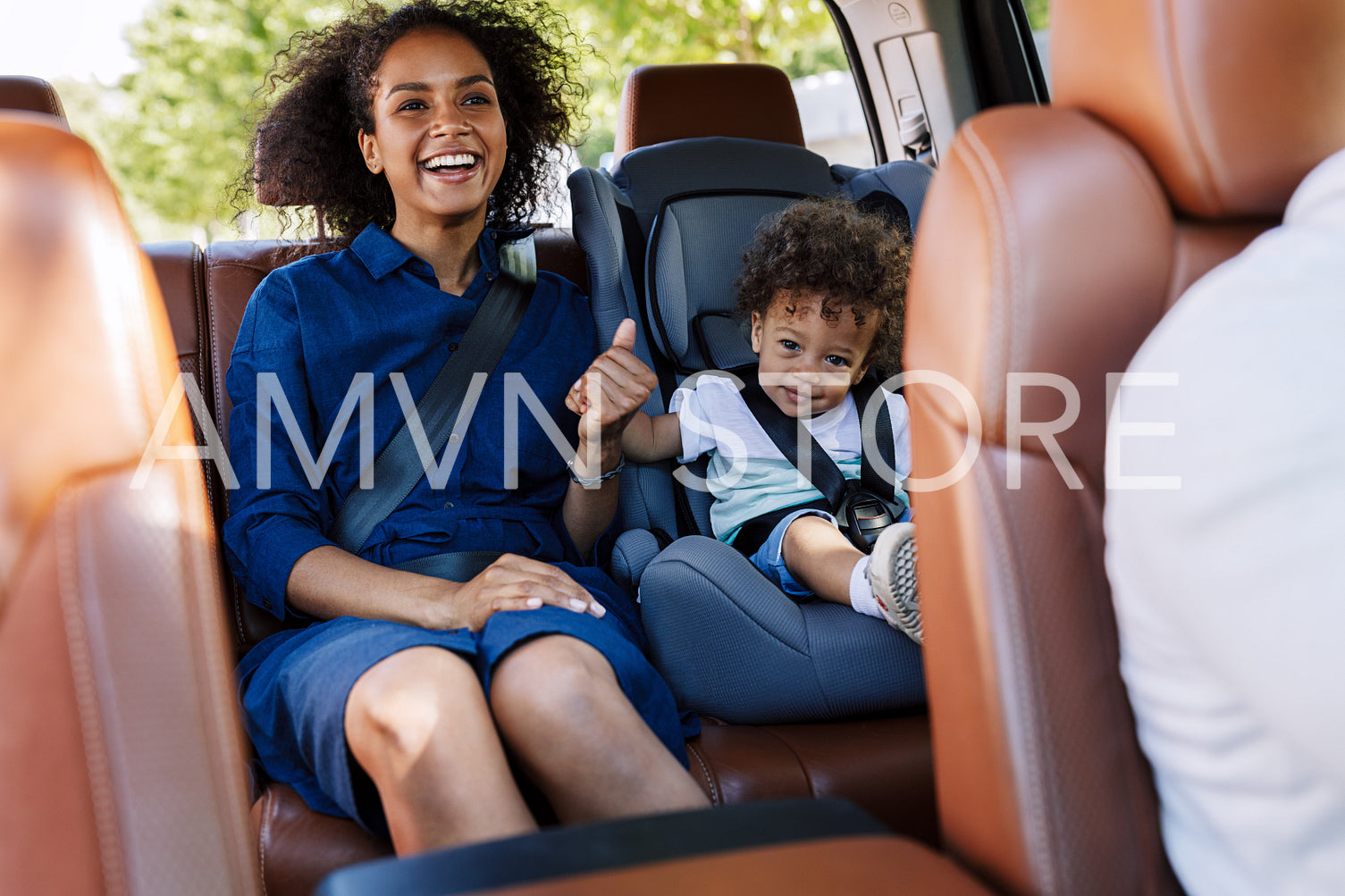 Happy mother and her son sitting on a backseat while traveling in a car	