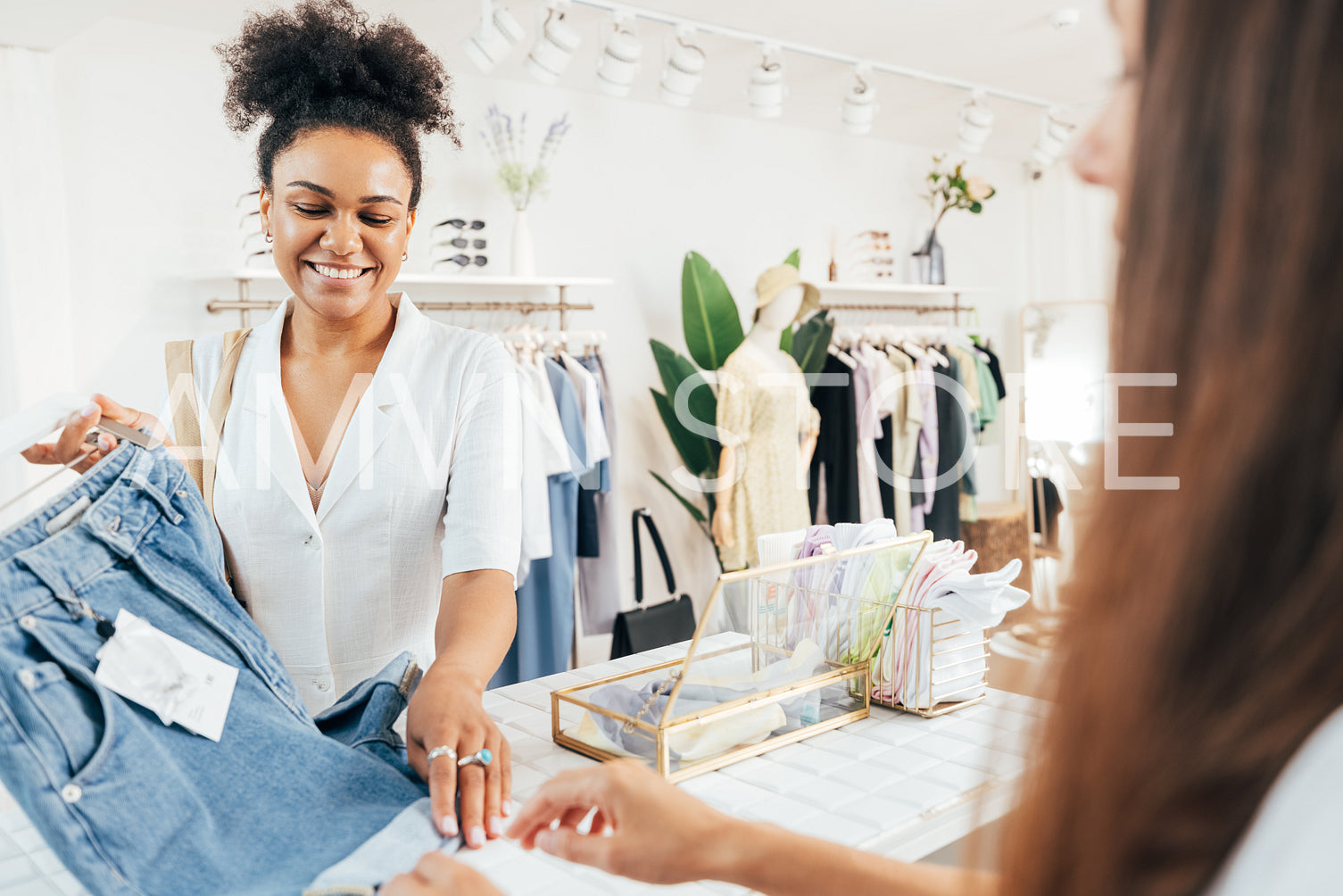 Young stylish woman buying clothes in boutique standing at the checkout counter