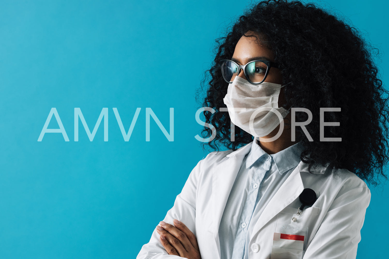 Confident female doctor wearing eyeglasses and protective mask looking away over blue background