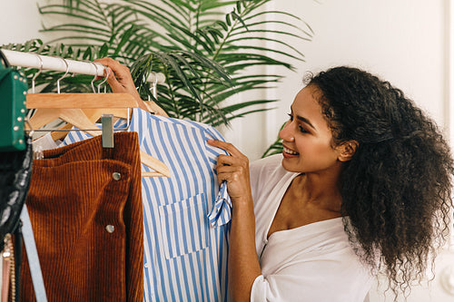 Smiling fashion buyer choose clothes on a rack