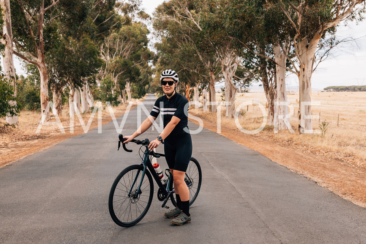 Athlete taking a break from cycling on an empty country road