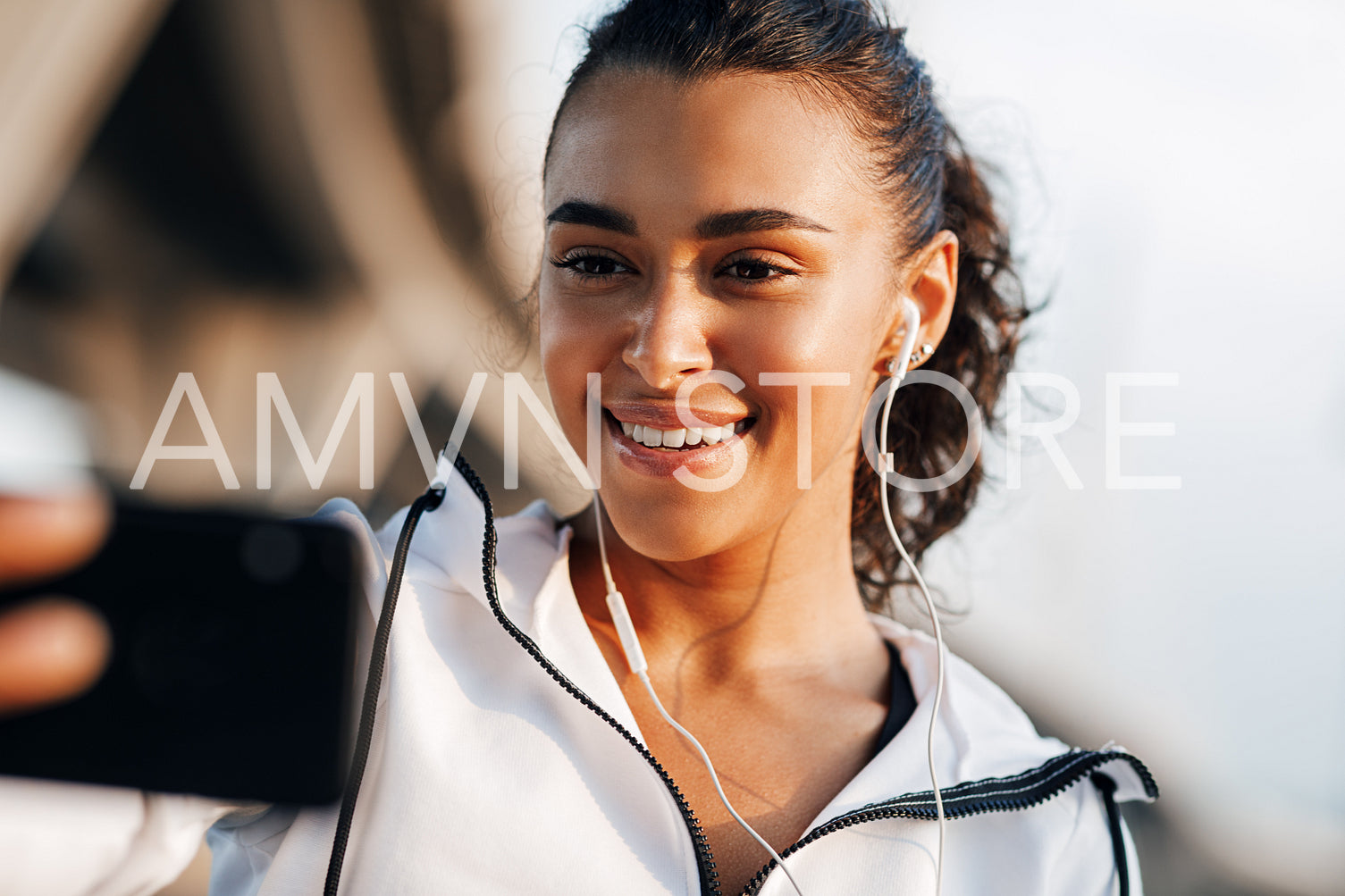 Smiling woman looking on her smartphone during workout taking selfie	