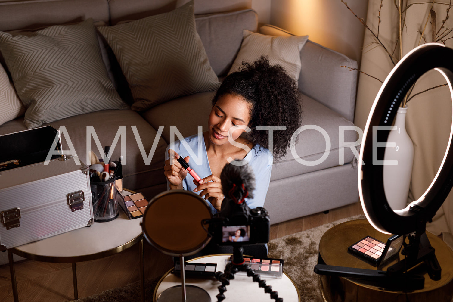 Beauty vlogger holding lipstick while recording makeup tutorial	