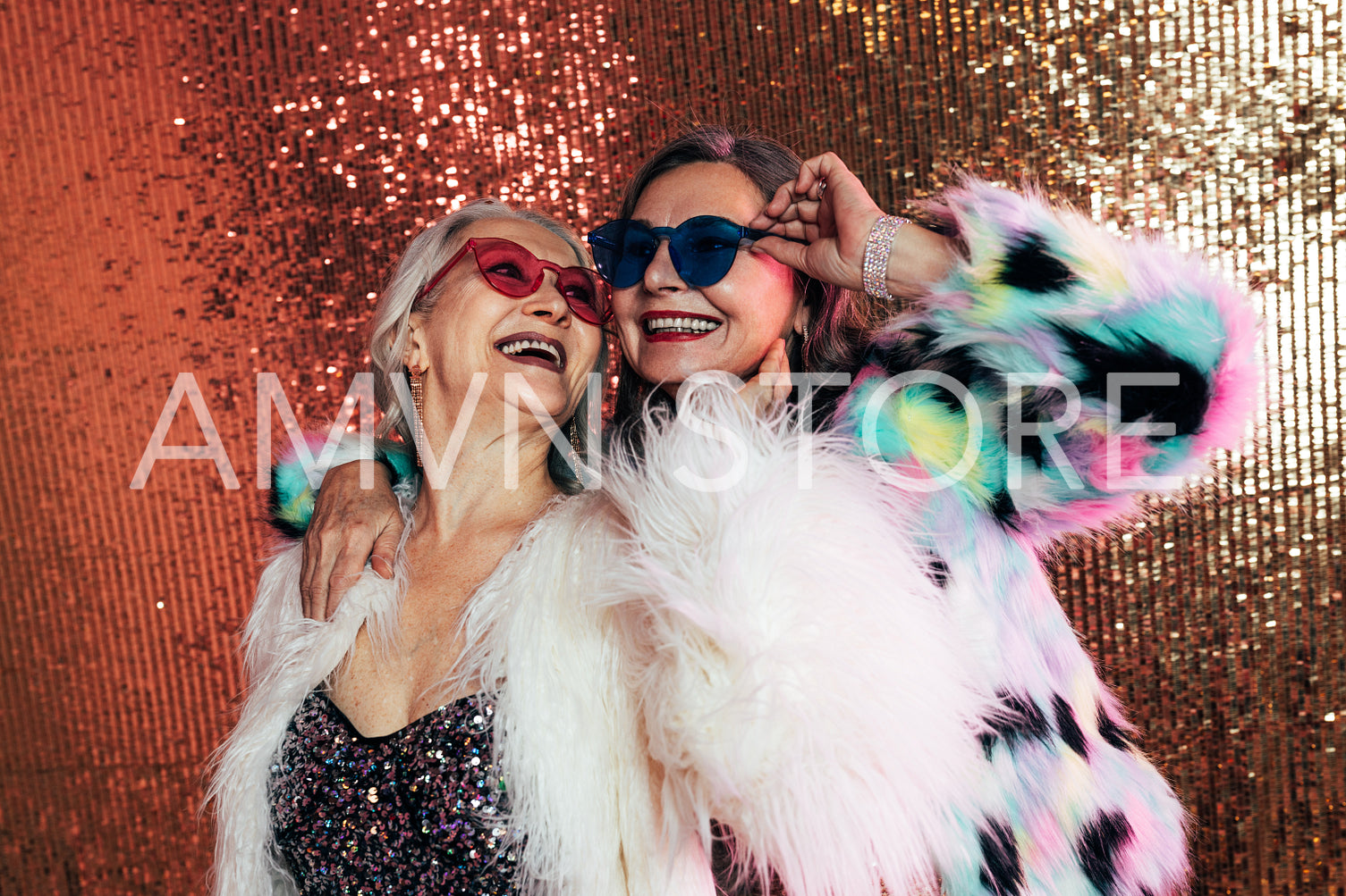 Two women wearing eyeglasses and fur coats. Senior females laugh