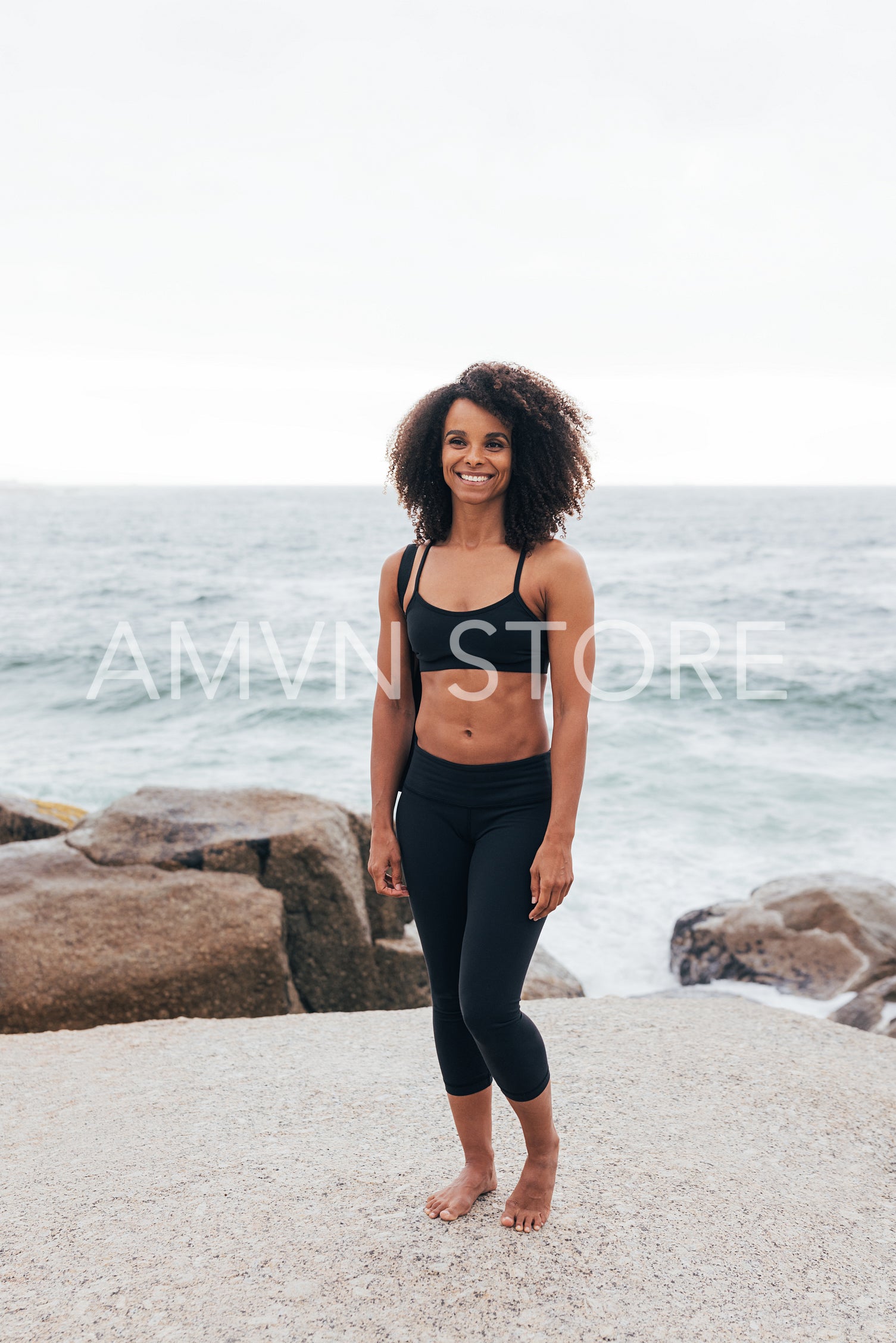 Full length of slim woman with a mat by the ocean