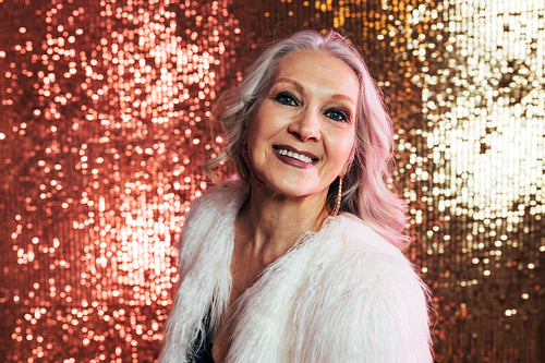 Portrait of a cheerful senior woman posing in studio and looking