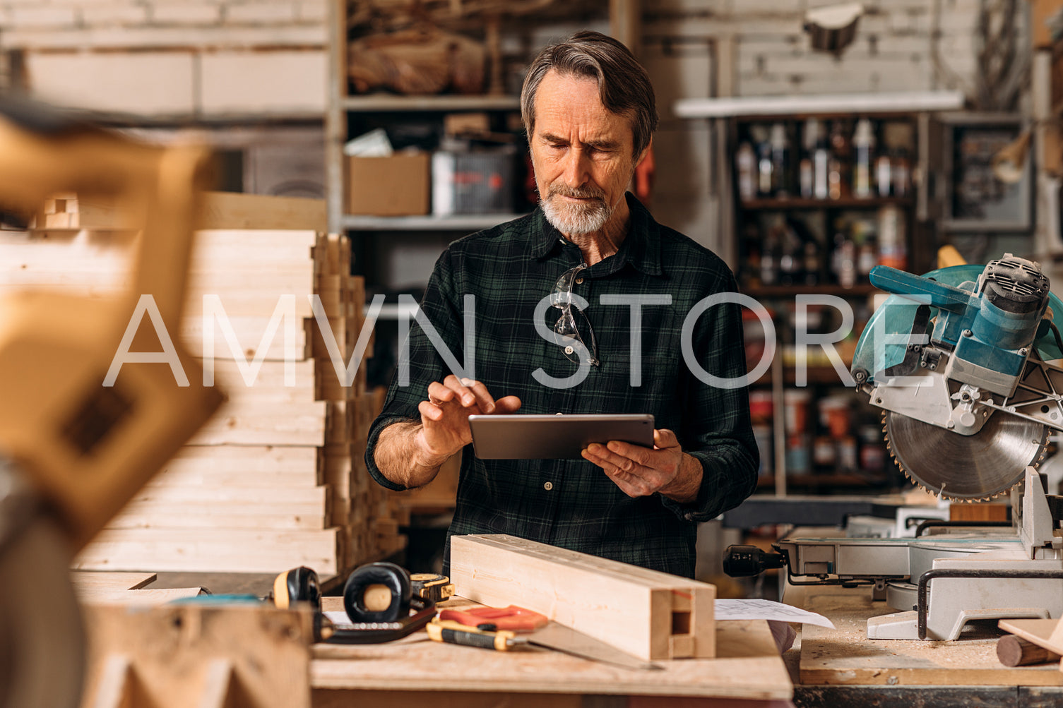 Senior carpenter using a digital tablet in his workshop	