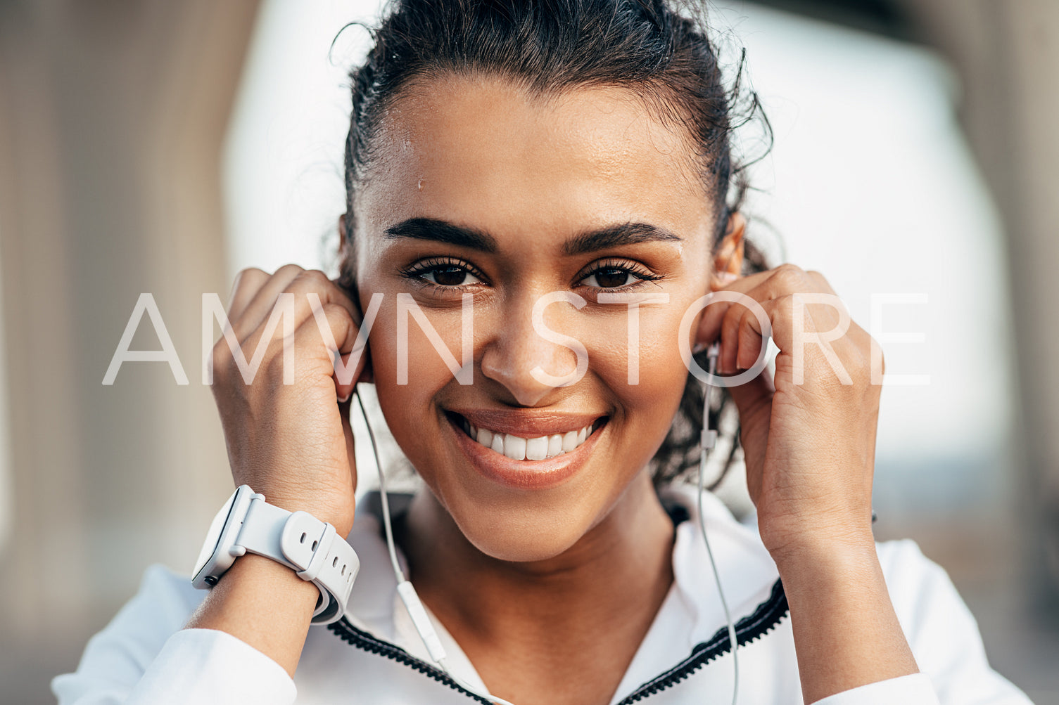 Close up portrait of a beautiful woman looking at camera and holding earphones	