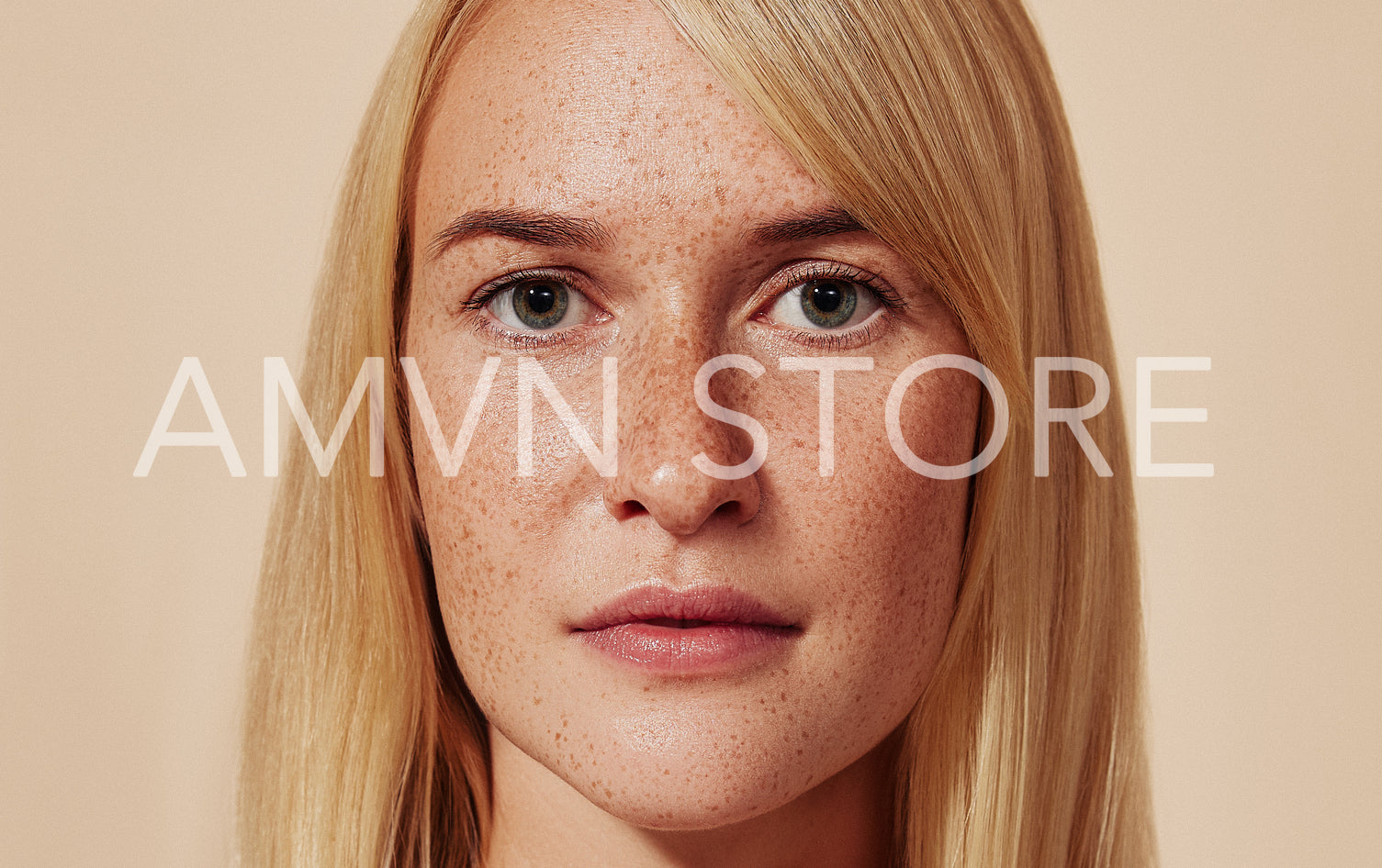 Close-up studio portrait of a blond female with freckles. Cropped shot of woman with smooth skin. Highly detailed image of a young female with perfect skin.