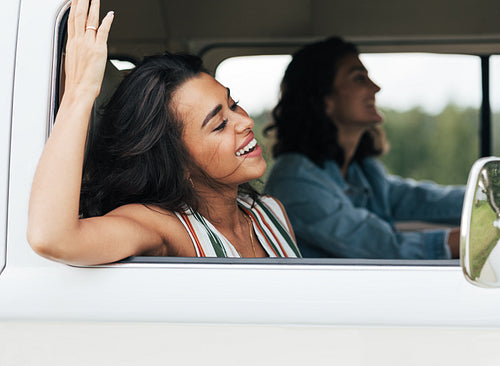 Side view of two women sitting in minivan during a summer road trip