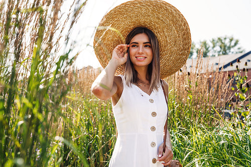 Young stylish woman looking away while standing on a field