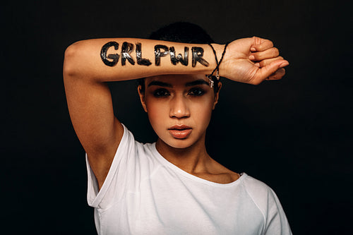 Young woman showing letters "GRL PRW" written on her hand