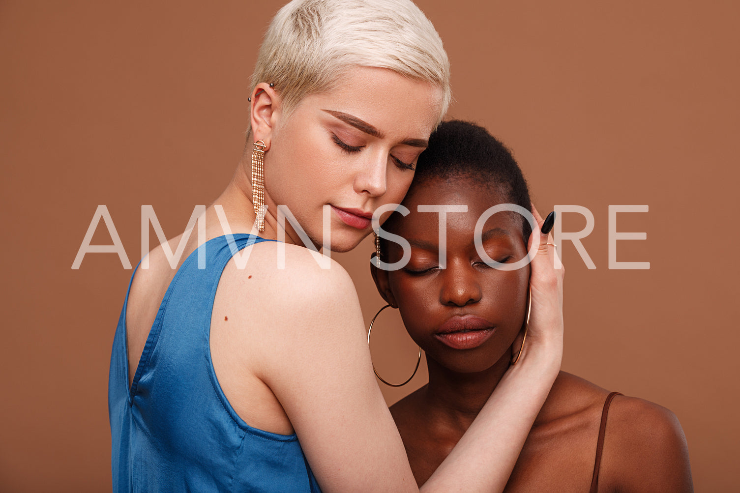 Two women with a different skin colors standing head to head with closed eyes 