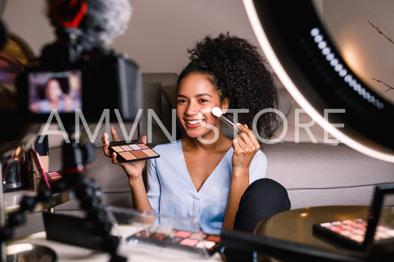 Beauty vlogger making a video tutorial on makeup in living room	