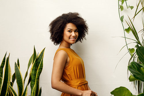 Smiling woman posing at the wall in her botanical studio