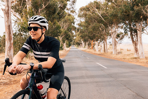 Woman cyclist sitting on her bike resting during outdoors ride