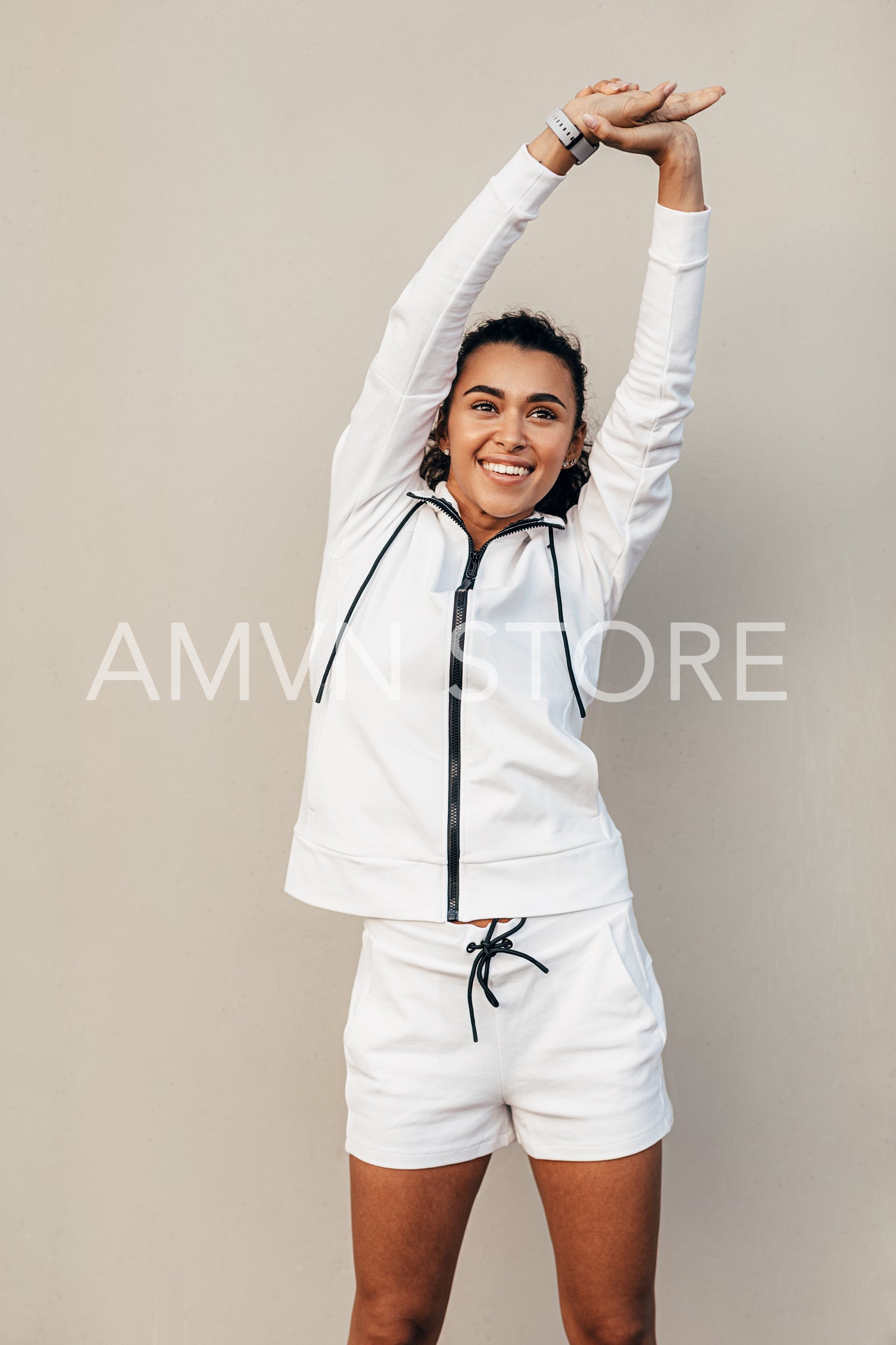 Smiling sportswoman doing stretching exercises at a wall	